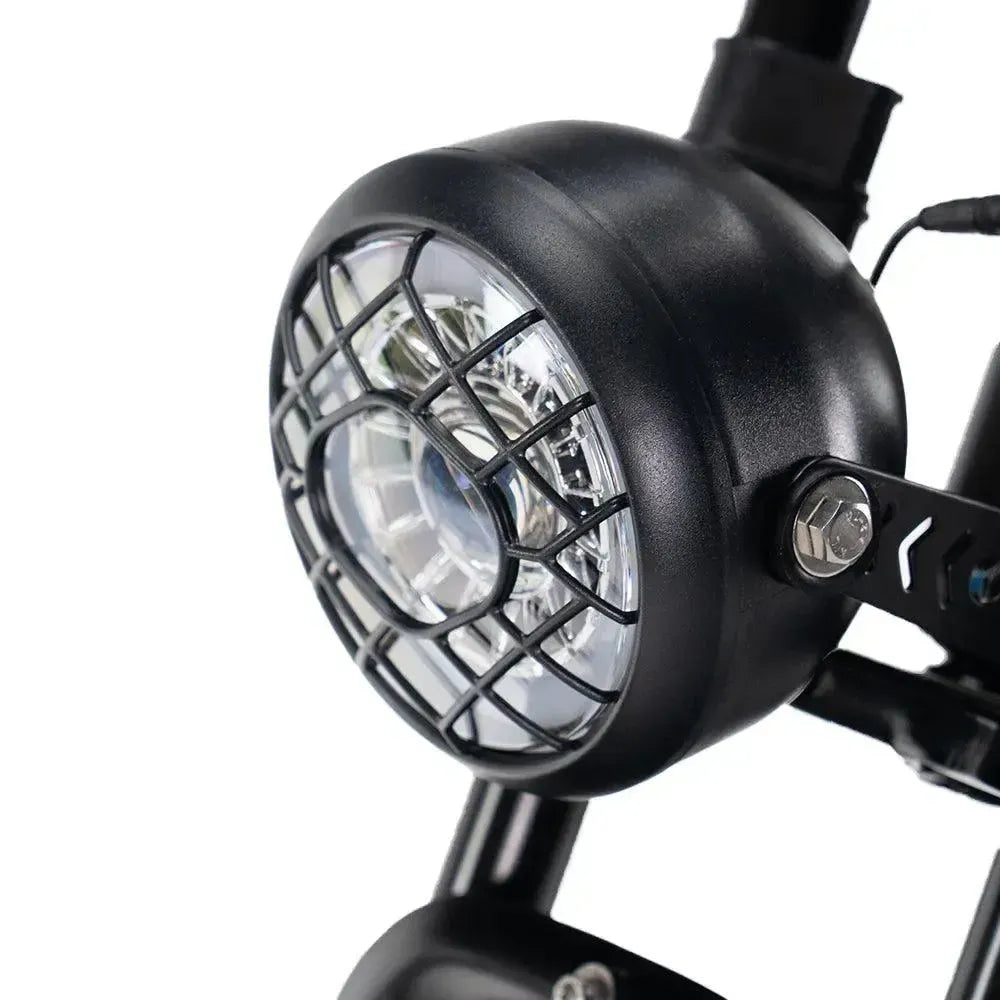 Ouxi V8 2025 fatbike in zwart, detail van de ronde LED-koplamp met zwart beschermrooster