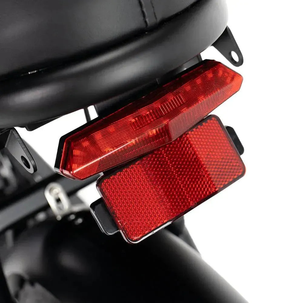 Ouxi V8 2025 fatbike in zwart, detail van het rode achterlicht met reflector onder het zadel